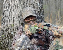 Turkey hunter by tree trunk